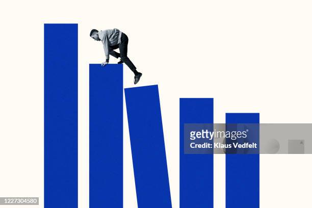 young man climbing up on blue bar graphs - odds stock-fotos und bilder