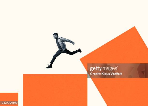 happy young man running on large orange bar graph - saltare foto e immagini stock