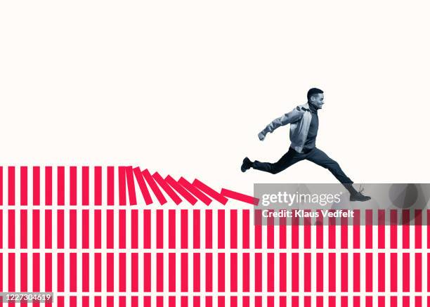happy young man running on red columns - social impact stock pictures, royalty-free photos & images