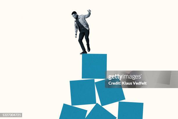 full length of young man balancing on blue blocks - man full length isolated stock pictures, royalty-free photos & images