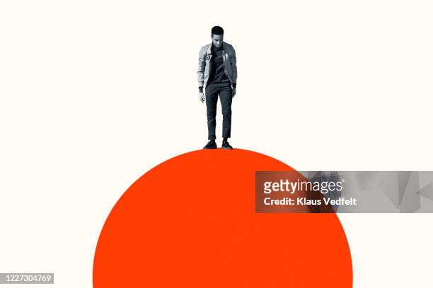 young man standing on top of orange semi-circle - öresundregion stock-fotos und bilder
