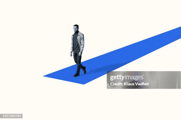 confident young man walking on blue ramp - catwalk stockfoto's en -beelden