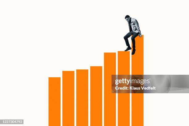 successful man sitting on top of orange bar graph - orange jacket stock pictures, royalty-free photos & images