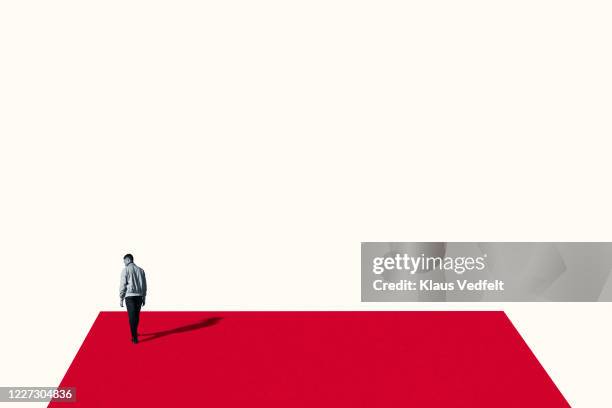 rear view of sad young man walking on red ramp - one man only stock pictures, royalty-free photos & images