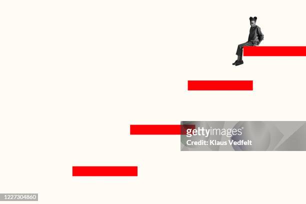 side view of scared woman sitting on top red step - escalón y escalera fotografías e imágenes de stock