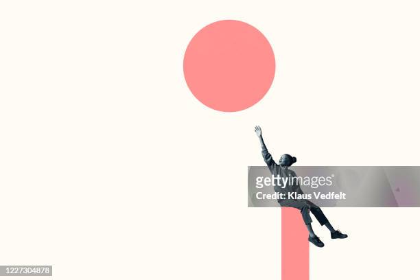 woman sitting on column while reaching for circle - goals stock pictures, royalty-free photos & images