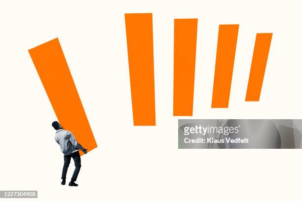 rear view of young man arranging orange bar graph - uithoudingsvermogen stockfoto's en -beelden