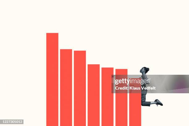 confident young woman climbing orange bar graph - bias line stockfoto's en -beelden