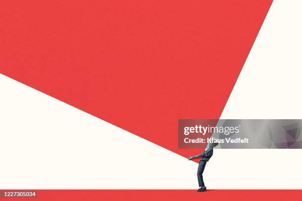 side view of young woman carrying large red block - supervivientes fotografías e imágenes de stock