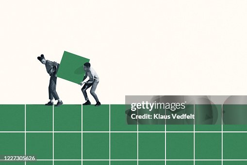 Woman and man carrying large green block on grid Woman and man carrying large green block on grid
