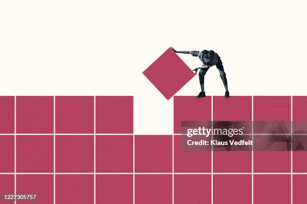 woman positioning final magenta block in grid - organization culture stock pictures, royalty-free photos & images