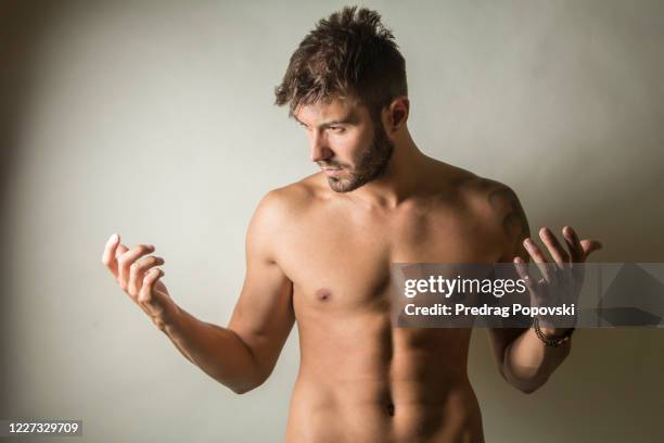 young muscular handsome shirtless man on dark studio background - male torso stock pictures, royalty-free photos & images