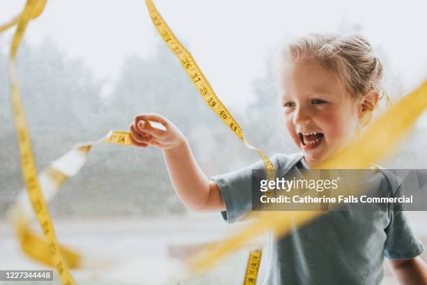 child with a measuring tape - mass unit of measurement stock-fotos und bilder