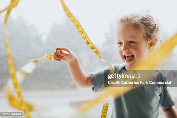 child with a measuring tape - largo longitud fotografías e imágenes de stock