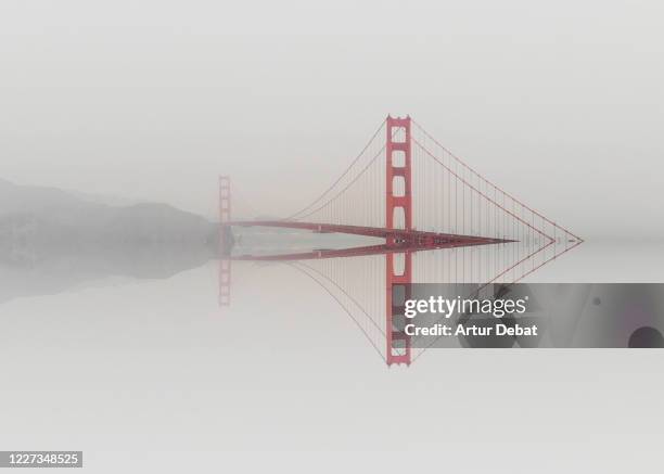 mirror distortion effect of the golden gate bridge emerging from water. - internationaal monument stockfoto's en -beelden