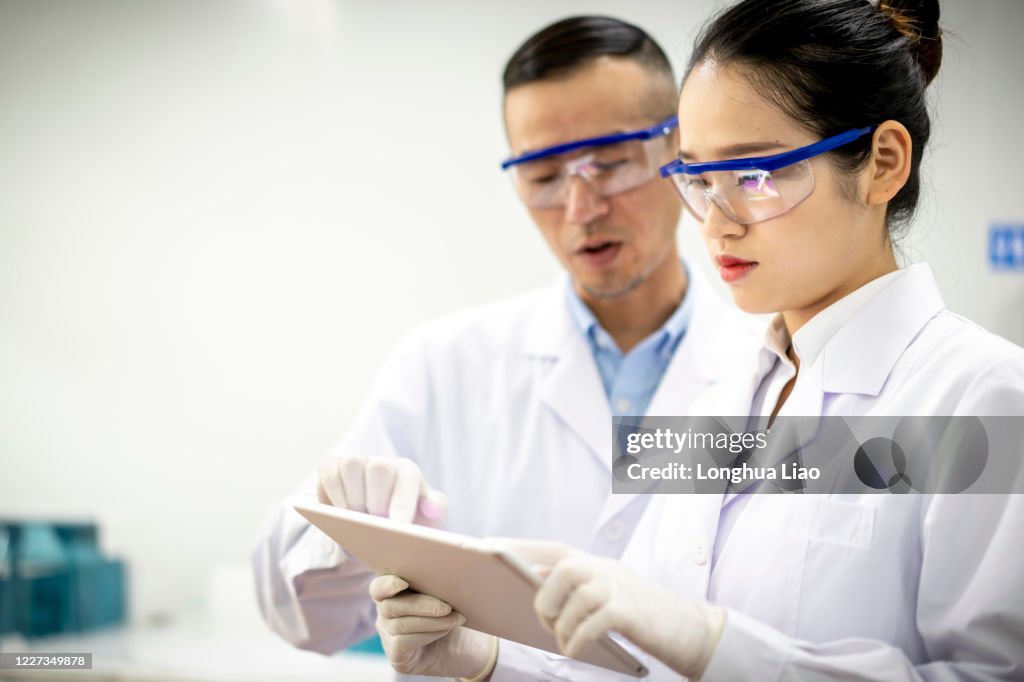 Two Asian scientists are talking in the laboratory