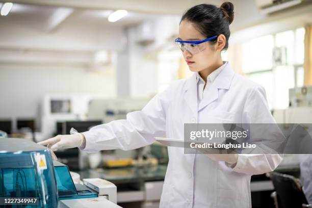 an asian scientist operates in a laboratory - chemical manufacturing stock pictures, royalty-free photos & images