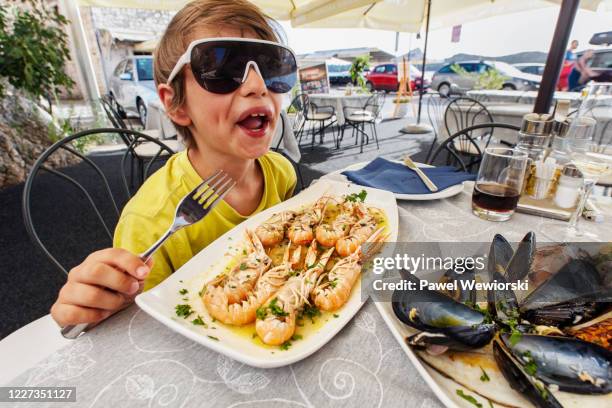 boy with plate of prawns - sibenik stock pictures, royalty-free photos & images