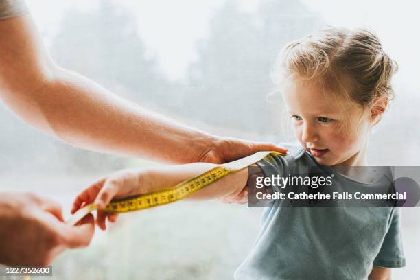 measuring a child's arm - mass unit of measurement stock-fotos und bilder
