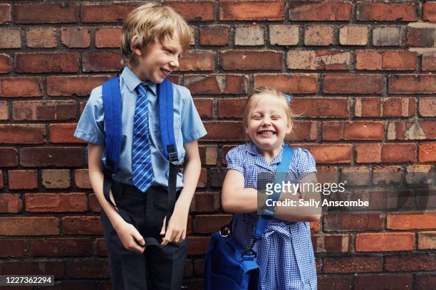 two happy smiling school children - school uniform stock pictures, royalty-free photos & images