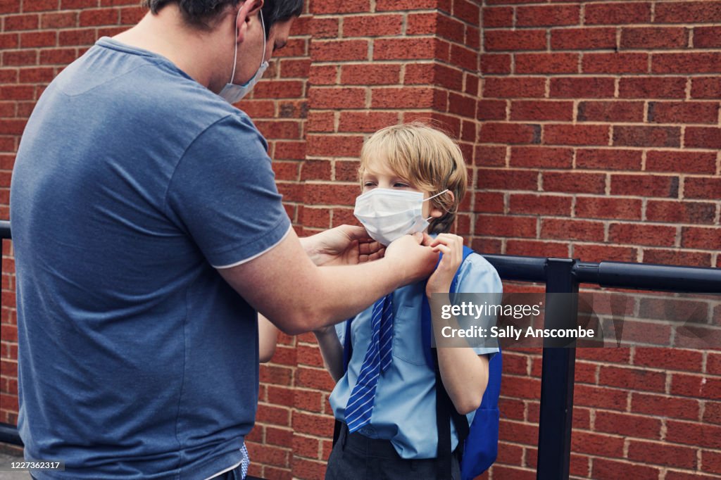 Father putting a mask mask on a child