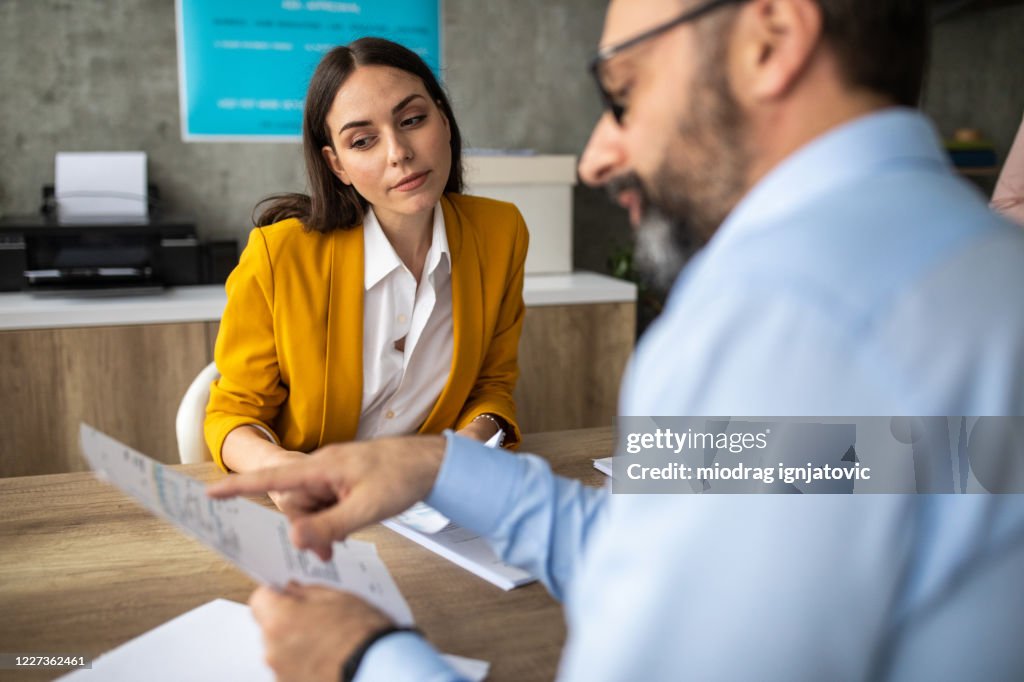 Coworkers working together on documents at office