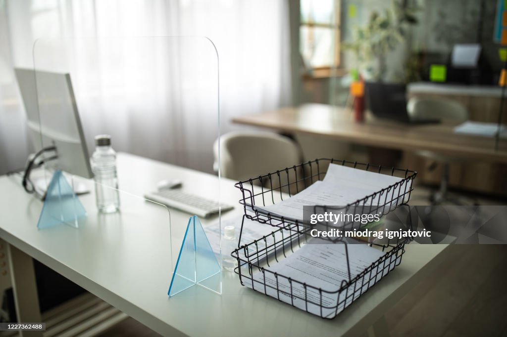 Desk with sneeze guard on it in bank office
