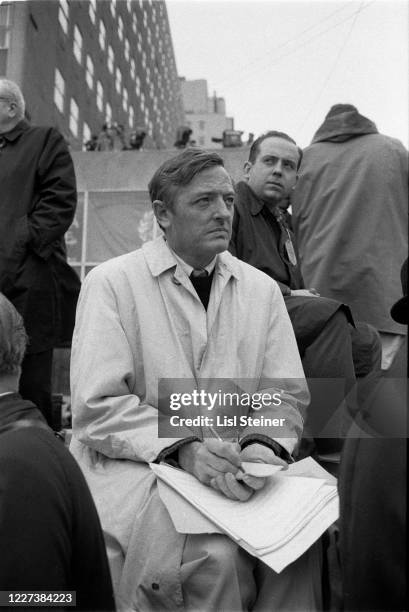 View of American journalist, author, and founder of the National Review William F Buckley Jr as he takes notes during the National Mobilization...