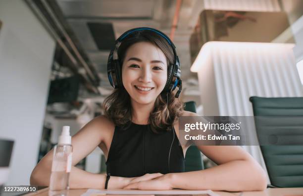 een aziatische chinese mooie vrouwen witte boordenarbeider die aan de video die videoconferentie van de camera roept met zijn bedrijfspartners met gezichtsmasker spreekt - chinese people posing for camera stockfoto's en -beelden