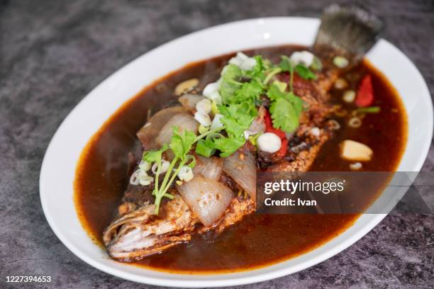 red braised belt fish with sweet and sour sauce on black background - channidi foto e immagini stock