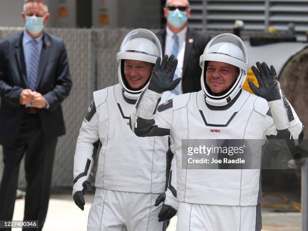 Astronauts Bob Behnken and Doug Hurley walk out of the Operations and Checkout Building on their way to the SpaceX Falcon 9 rocket with the Crew...