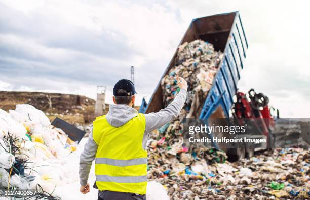 rear view of man worker on landfill, waste management and environmental concept. - nuclear waste management stock pictures, royalty-free photos & images