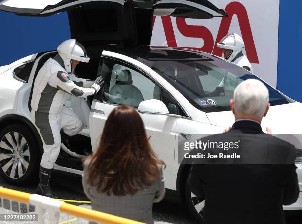 Vice President Mike Pence and his wife Karen Pence watch as NASA astronauts Bob Behnken and Doug Hurley get into a Tesla vehicle after walking out of...
