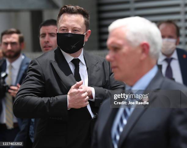 SpaceX founder Elon Musk wears a face mask while standing next to U.S. Vice President Mike Pence after NASA astronauts Bob Behnken and Doug Hurley...