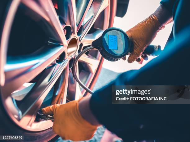 neumático inflado auto mechanic - inflar fotografías e imágenes de stock