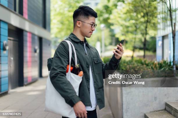 young man living a sustainable lifestyle - reusable bag stock pictures, royalty-free photos & images