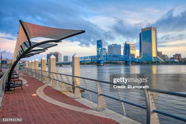 downtown jacksonville skyline at sunrise as seen from the southbank riverwalk along st. johns river in florida - jacksonville stock pictures, royalty-free photos & images