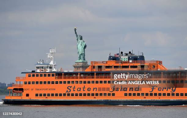 The Staten Island ferry passes in front of the Statue Of Liberty as seen from Governors Island on July 15, 2020 in New York City. - The 172-acre...