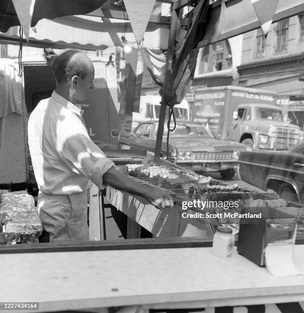 View of a man grilling skewered meats on Mulberry Street during the Feast Of San Gennaro Festival, in the Little Italy neighborhood, New York, New...
