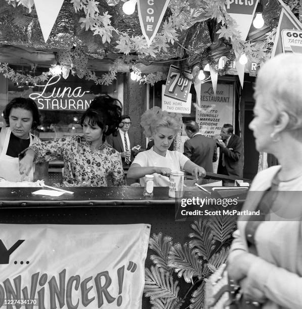 View of three women eating at a stand on Mulberry Street during the Feast Of San Gennaro Festival, in the Little Italy neighborhood, New York, New...