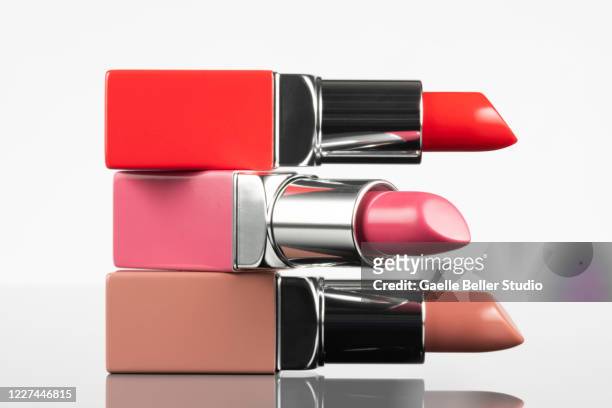 portrait of new lipsticks stacked against white background - rossetto foto e immagini stock