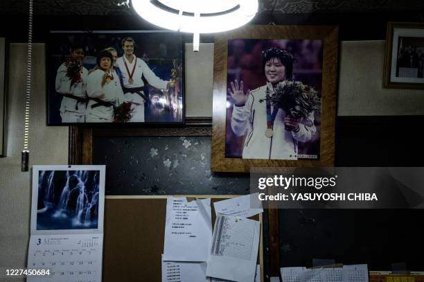 This picture taken on February 7, 2020 shows pictures of two-time Olympic judo gold medallist Masae Wakako of Japan on the podium at the Athens 2004...