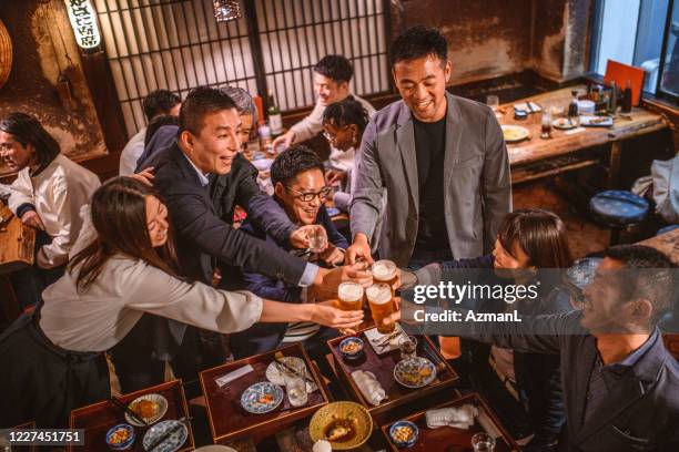 vista de ángulo alto de amigos japoneses divertidos tostados en izakaya - only japanese fotografías e imágenes de stock