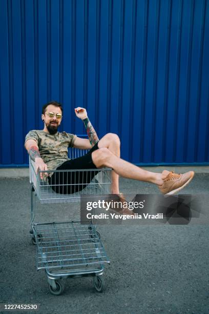 man with shopping cart - man pushing cart fun play stock pictures, royalty-free photos & images