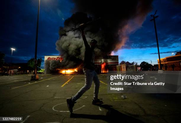 Minneapolis, MN May 27: A man ran through the parking lot as a fire blazed on at the AutoZone.