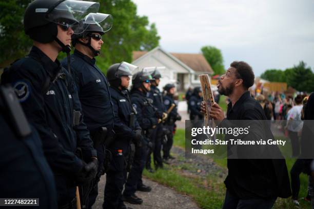 Demonstrator holding a sign jumped up and down so police officers behind the front lines could see it. Demonstrators protested the killing of George...