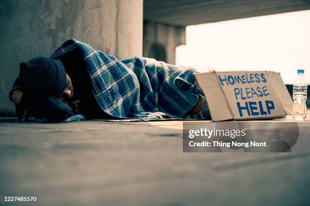 homeless man sleeping on cardboard - beggar photos et images de collection