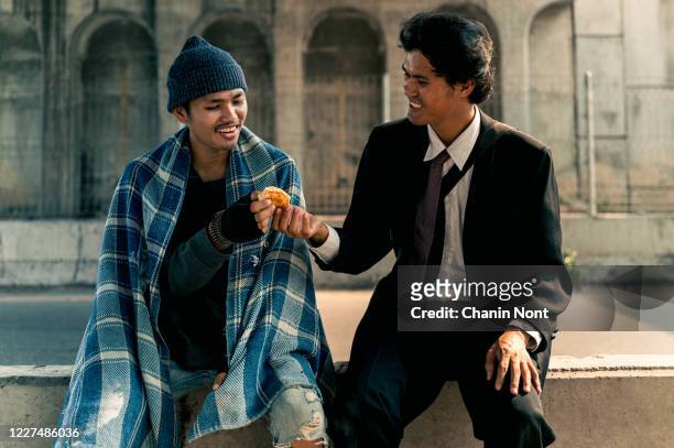 people give bread or sharing food to poor and homeless man to help his hungry for charity - asian beggar stock-fotos und bilder