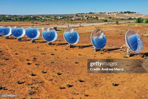 solar thermal power station with parabolic dish reflector in red dirt field, outback australia - mirror steam stockfoto's en -beelden