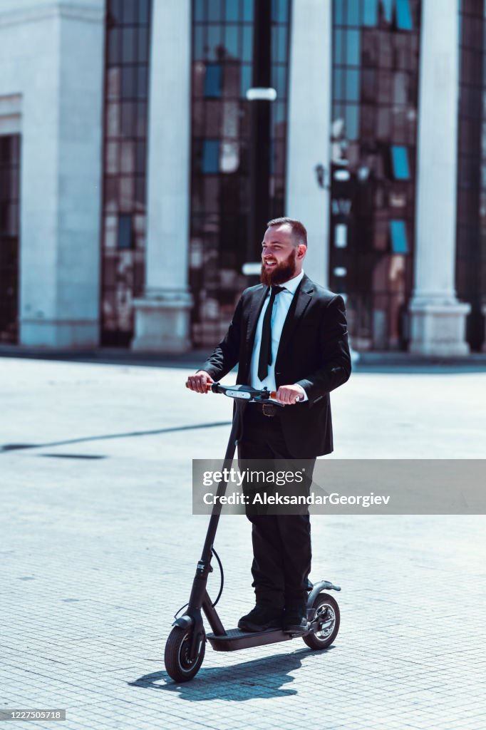 Handsome Businessman Enjoying Electric Scooter As Transport To Work